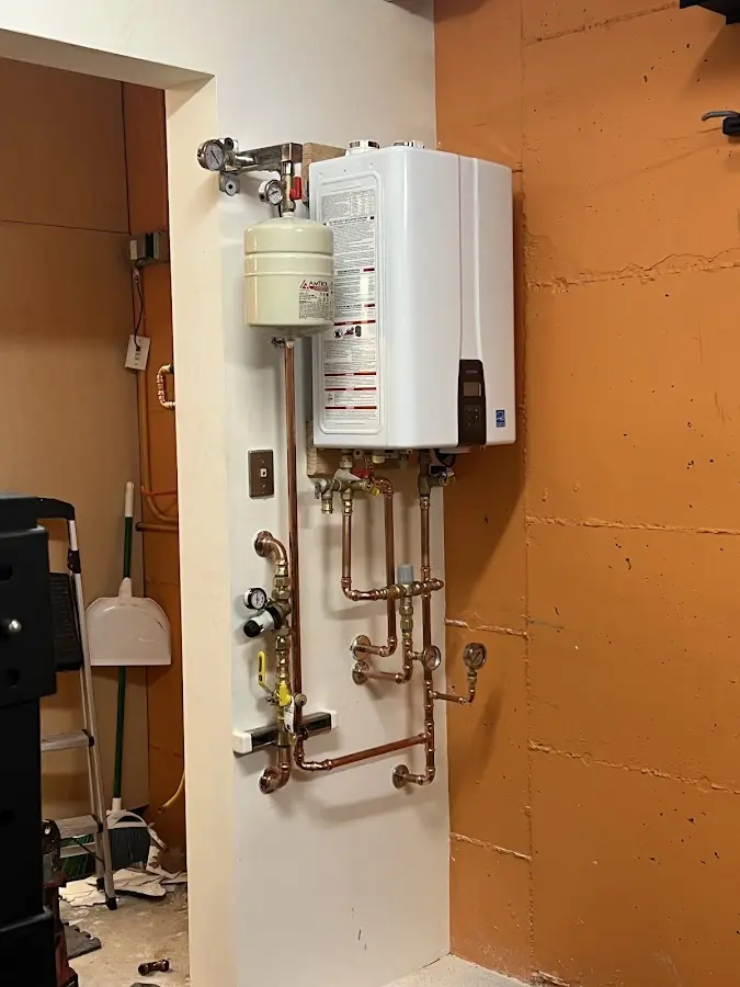 Plumbing technician inspecting water heater connections in Hideaway